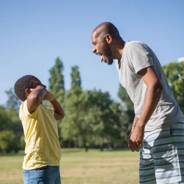 father son playful moment park